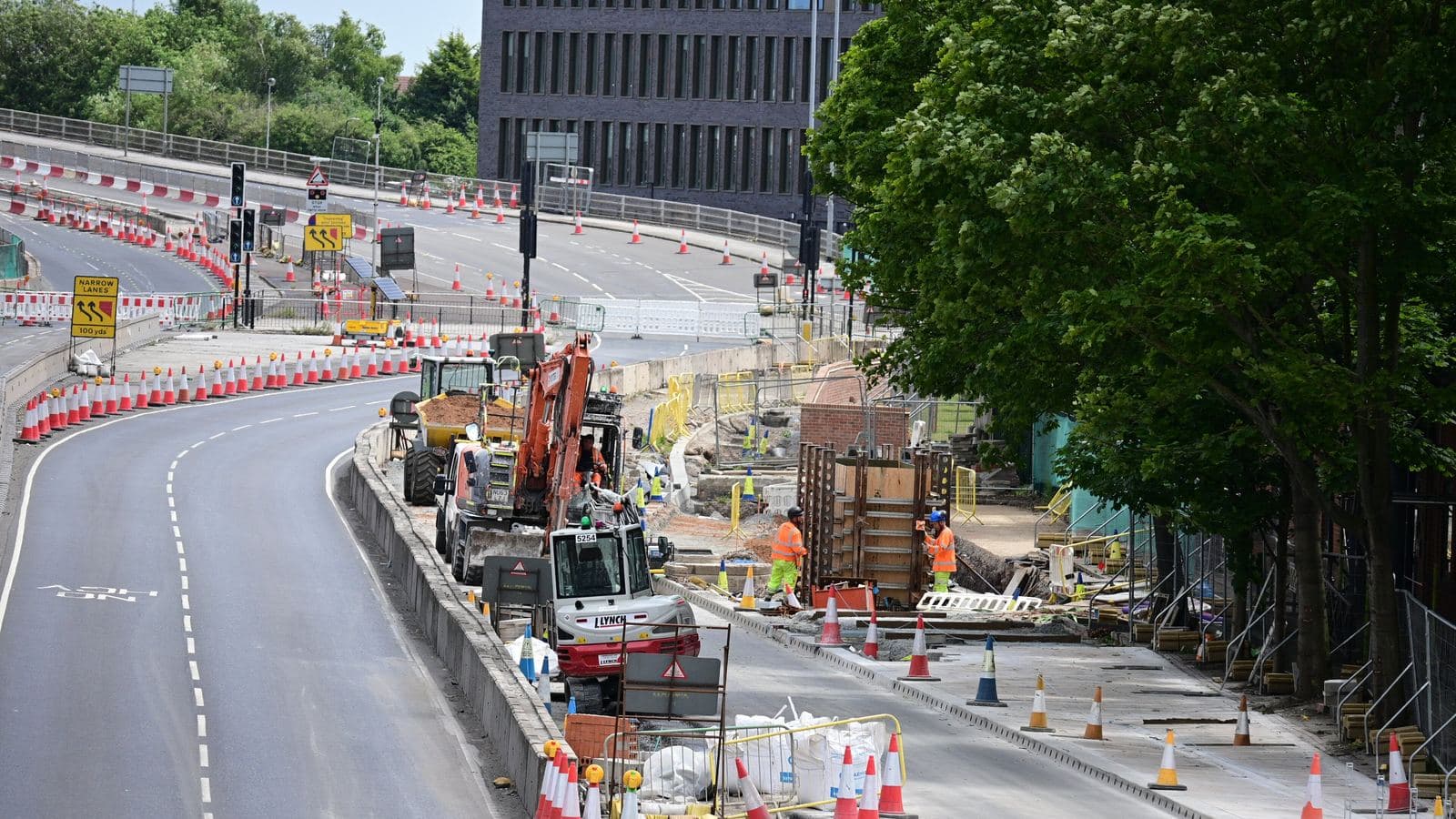 Site team working alongside road construction equipment
