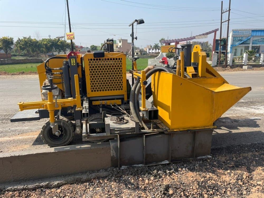 The Aptech ACP 40 is a compact automatic kerb paver machine, powered by a 16 HP engine, featuring a self-propelled chassis with an integrated concrete hopper and slipform mould system designed for laying continuous concrete kerbs and channels on smaller-scale road and pathway projects.
